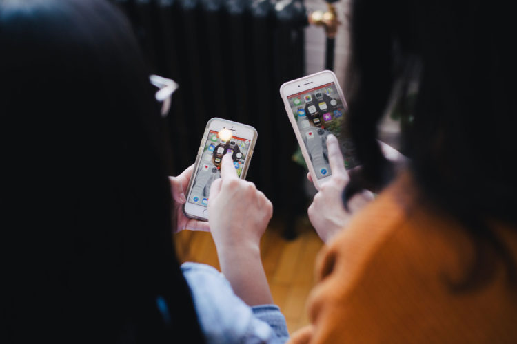 dos mujeres interactuando con sus moviles